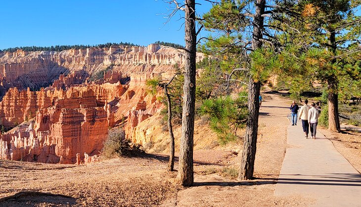 People walking on the Sunset Point to Sunrise Point trail in the morning