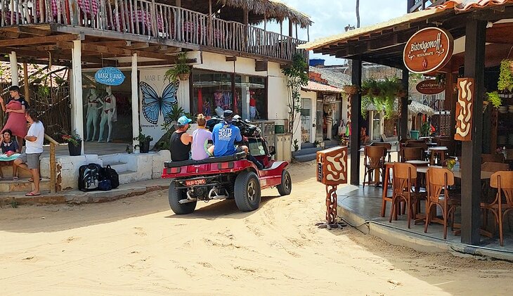 Three people on the back of a beach buggy